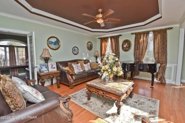 a dining room with furniture a chandelier and wooden floor