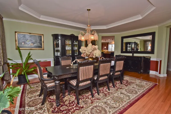 a dining room with furniture a chandelier and wooden floor