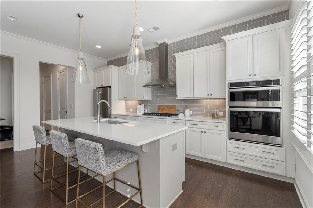 1076 Heyward Way Alpharetta, GA 30009 - Photo 12 of 57 a kitchen that has a lot of white cabinets and stainless steel appliances