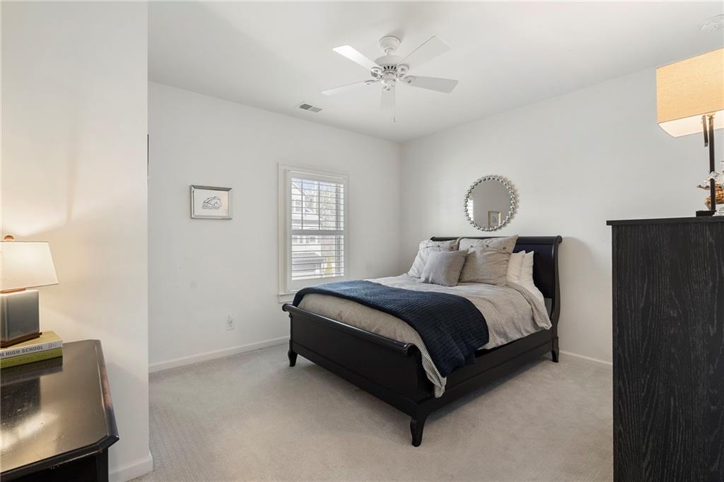 1076 Heyward Way Alpharetta, GA 30009 - Photo 26 of 57 a spacious bedroom with a bed and a chandelier