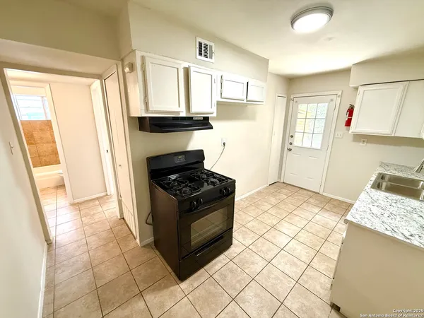 a kitchen with stainless steel appliances granite countertop a stove a refrigerator and a cabinets