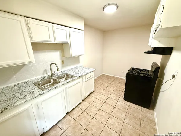 a kitchen with a sink and a stove top oven
