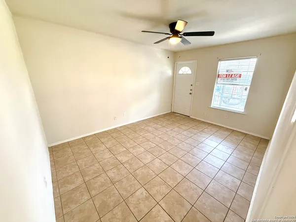 a view of an empty room and a ceiling fan