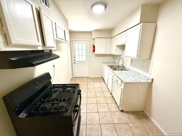 a kitchen with a sink a stove and a refrigerator