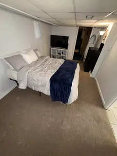 a spacious bedroom with a bed and a flat screen tv