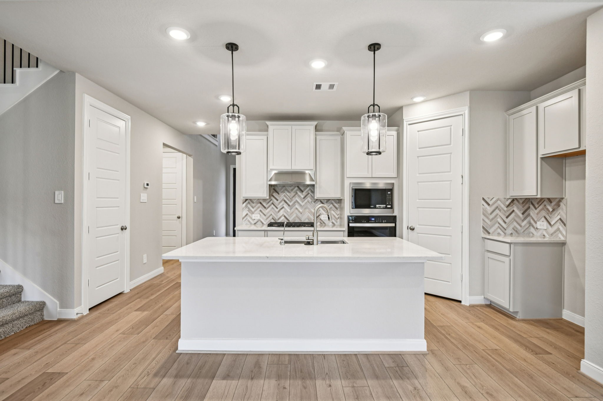 224 Raine Manor Montgomery, TX 77316 - Photo 14 of 50 a large kitchen with stainless steel appliances kitchen island granite countertop a refrigerator a stove and white cabinets with wooden floor