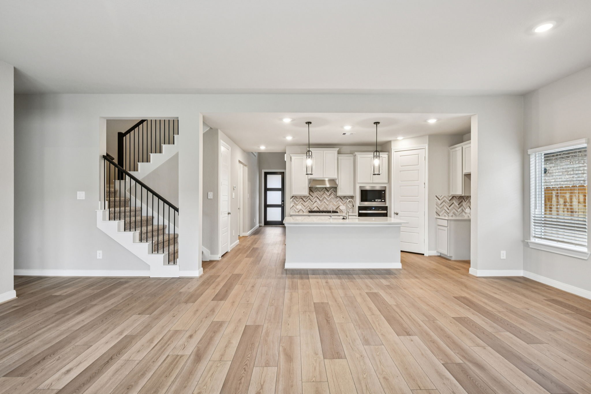 224 Raine Manor Montgomery, TX 77316 - Photo 9 of 50 a view of a living room and kitchen with furniture wooden floor and windows