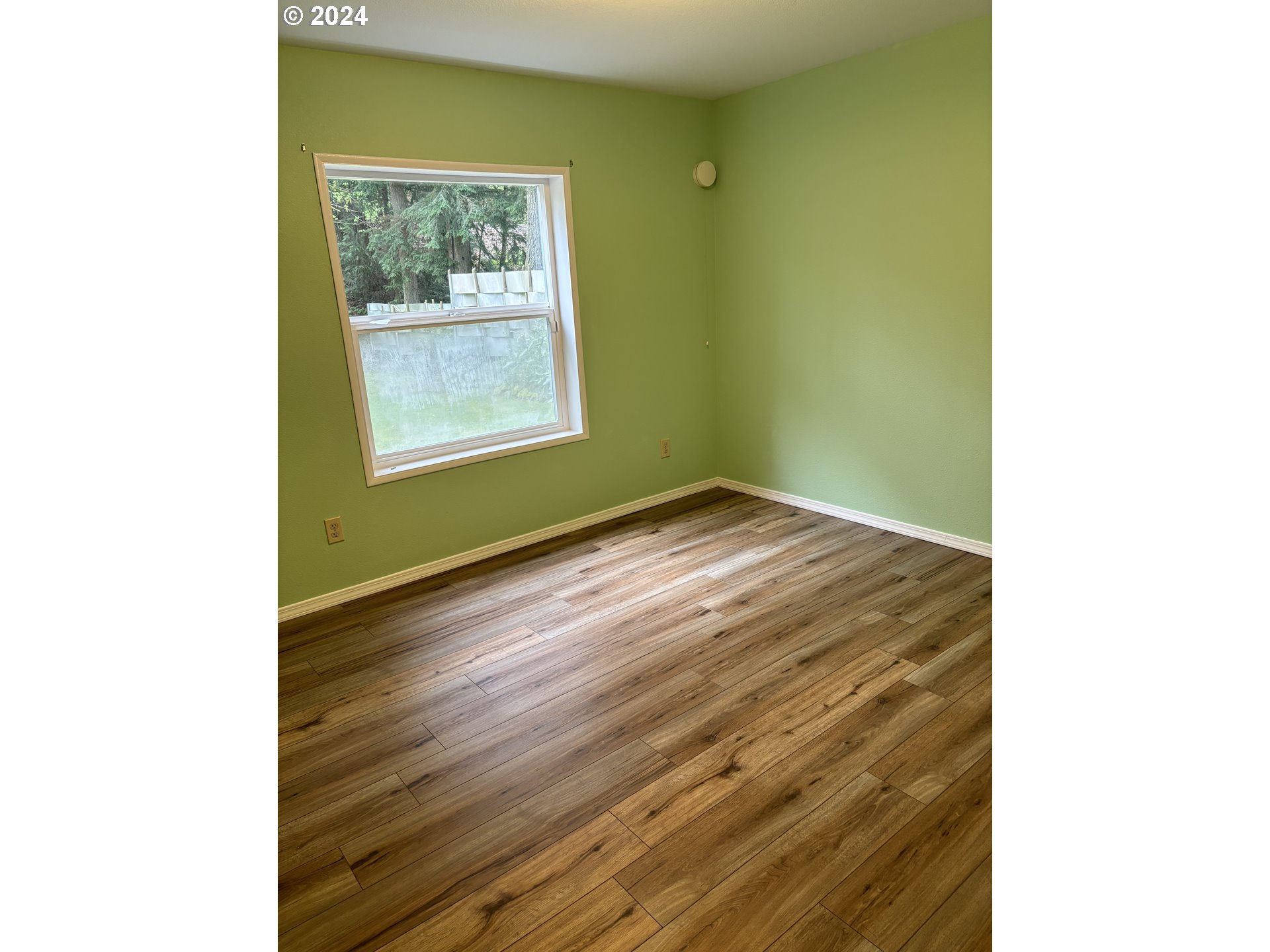629 Coal Creek Road Longview, WA 98632 - Photo 19 of 26 a view of an empty room with wooden floor and a window