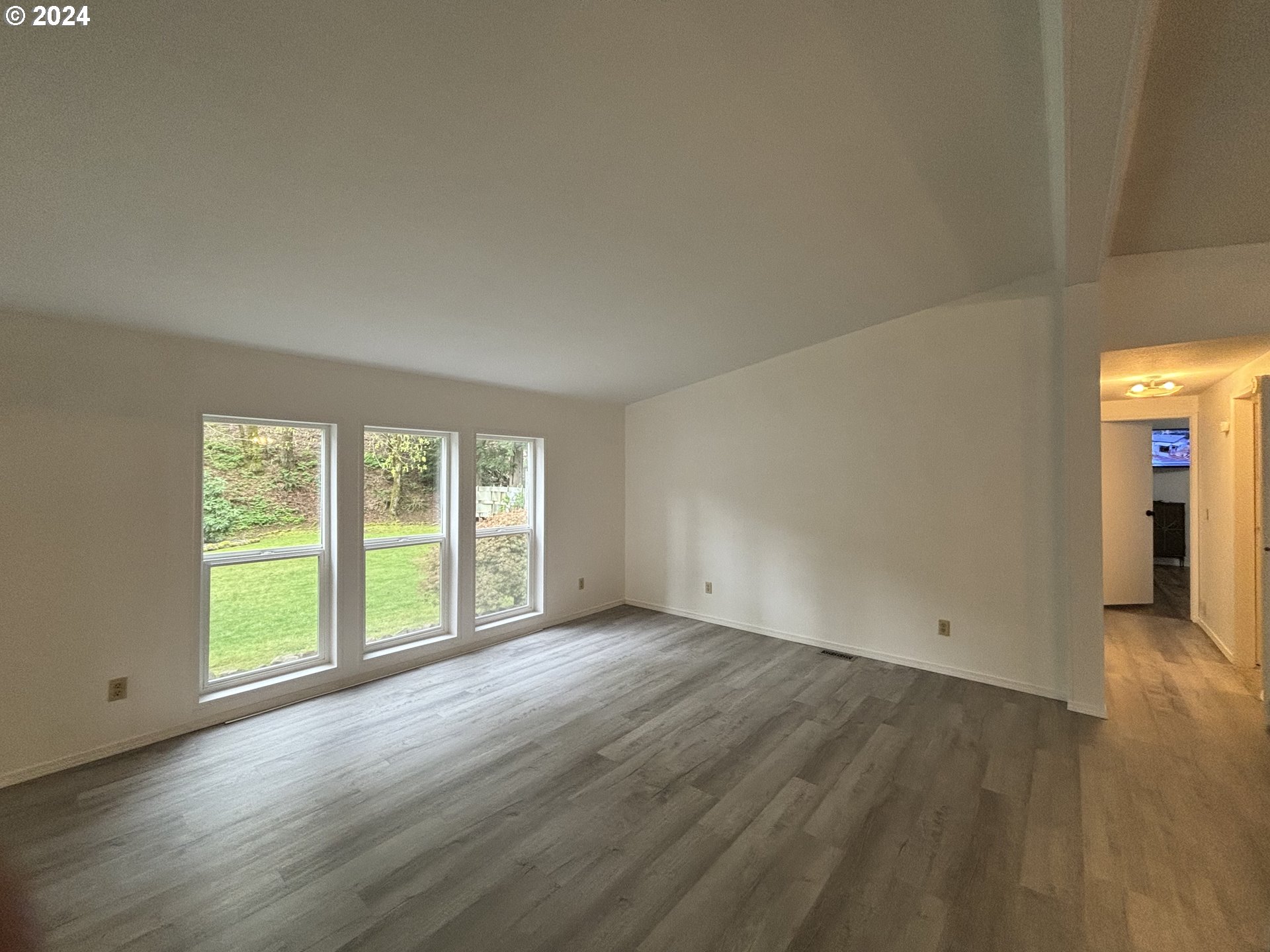 629 Coal Creek Road Longview, WA 98632 - Photo 3 of 26 an empty room with wooden floor and windows