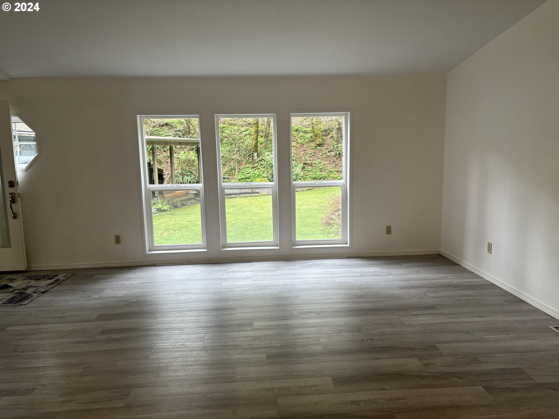 629 Coal Creek Road Longview, WA 98632 - Photo 4 of 26 a view of an empty room with wooden floor and a window