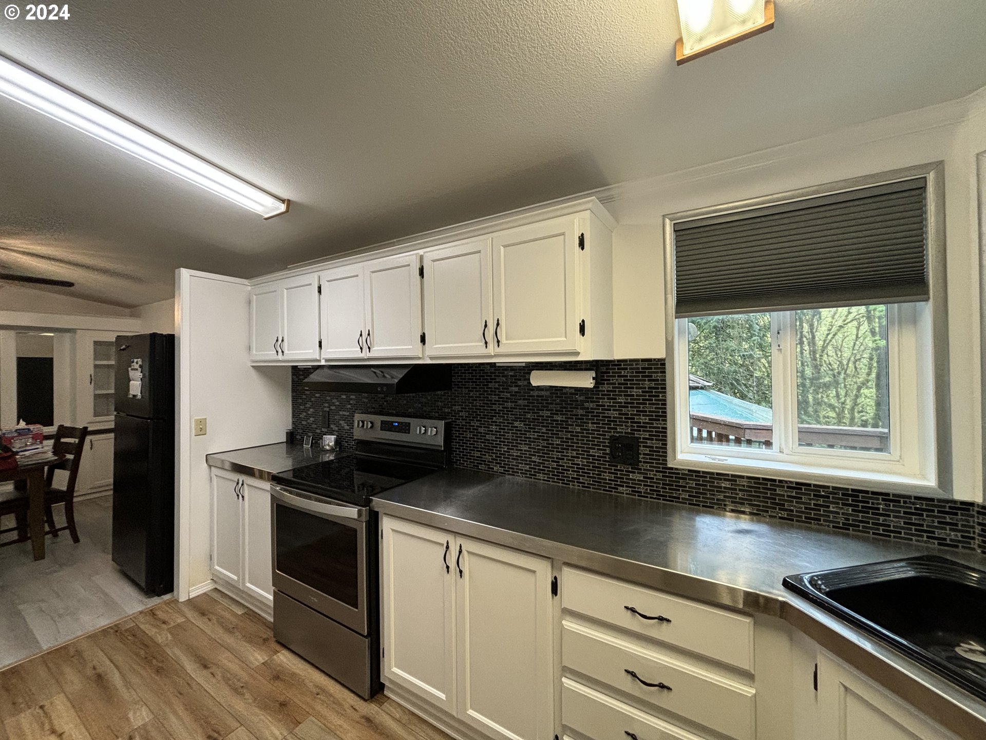 629 Coal Creek Road Longview, WA 98632 - Photo 6 of 26 a kitchen with granite countertop white cabinets and black appliances