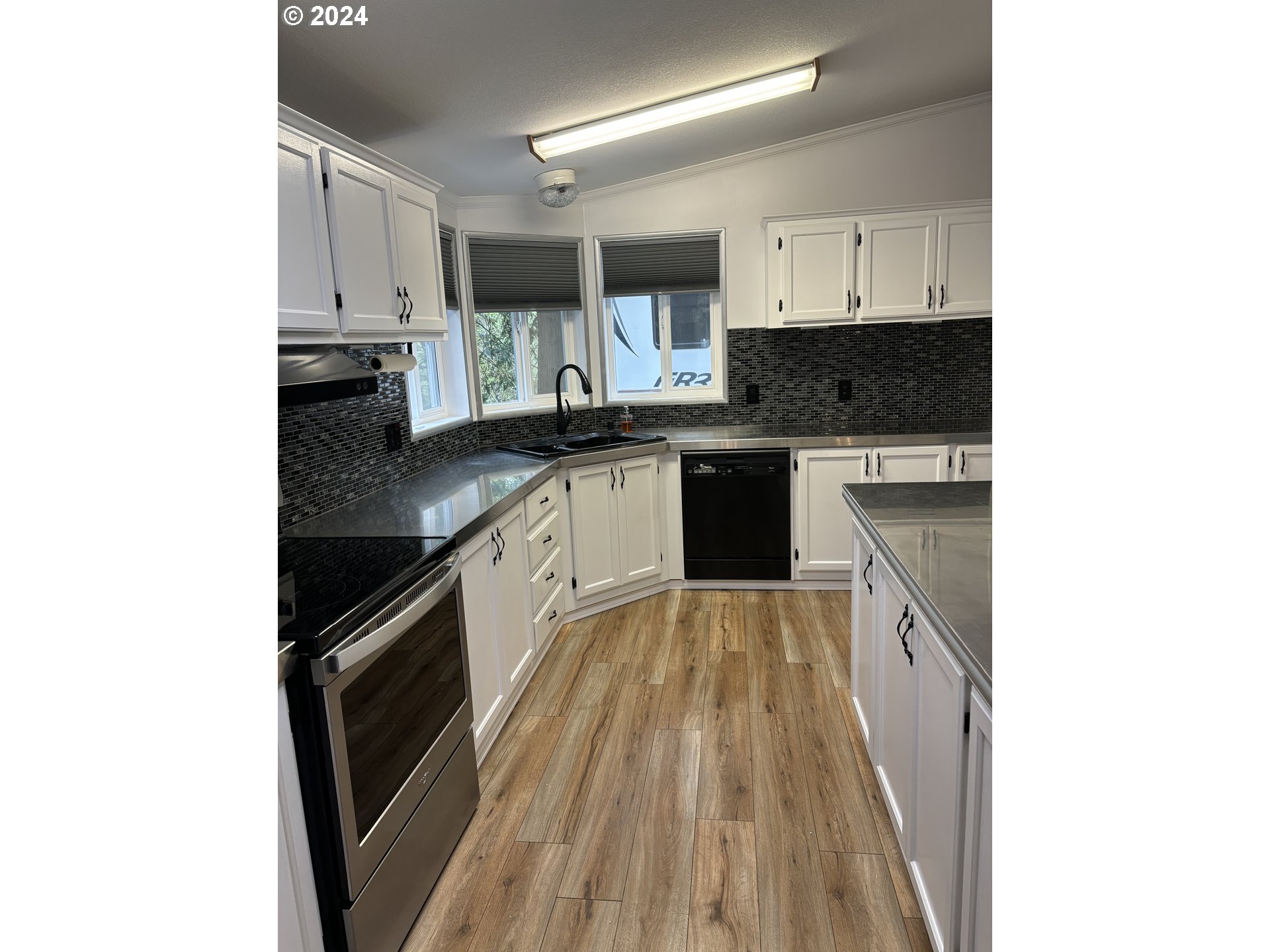 629 Coal Creek Road Longview, WA 98632 - Photo 7 of 26 a kitchen with kitchen island granite countertop a sink stove and cabinets