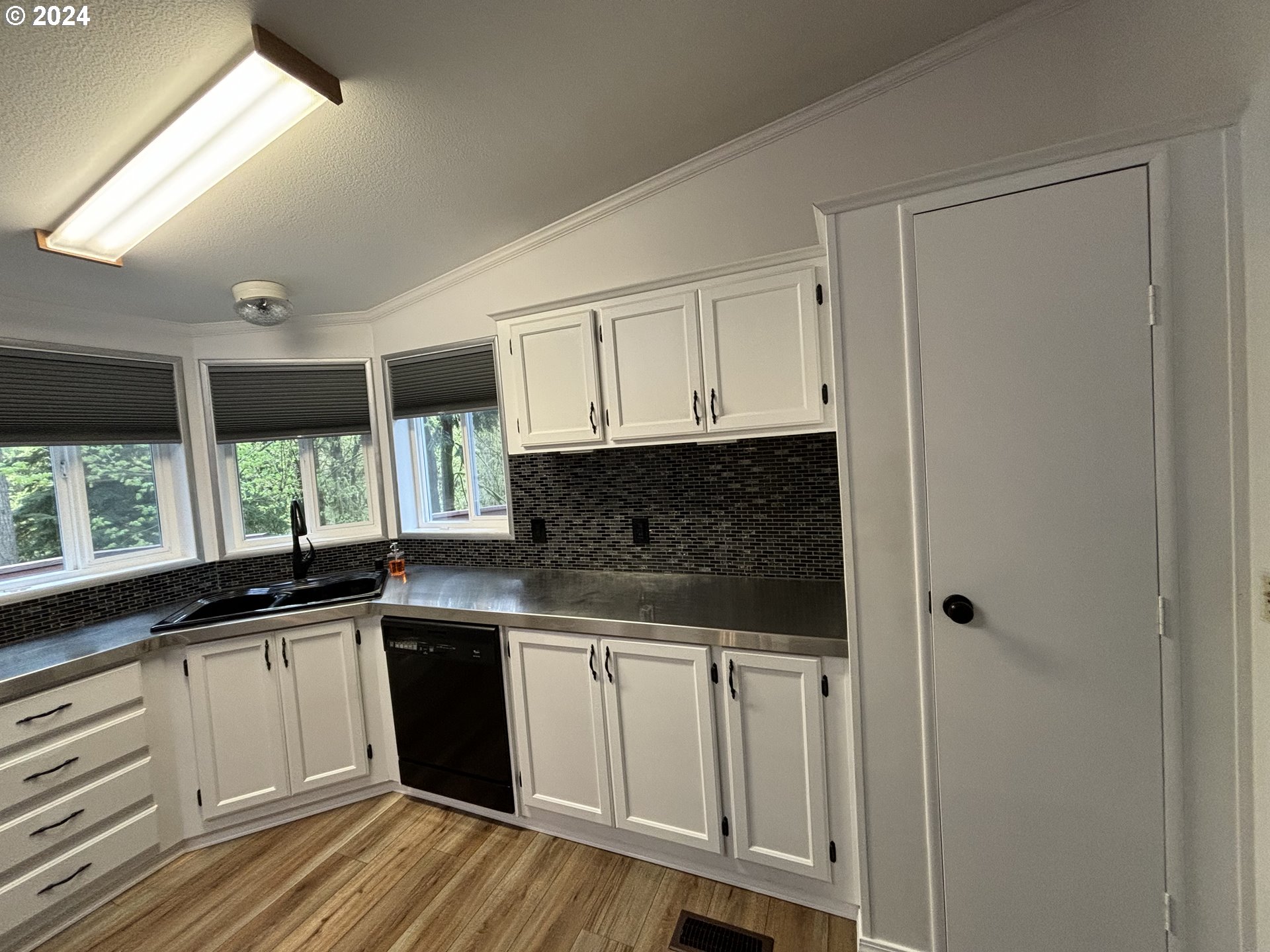 629 Coal Creek Road Longview, WA 98632 - Photo 8 of 26 a kitchen with stainless steel appliances granite countertop a sink and cabinets with wooden floor