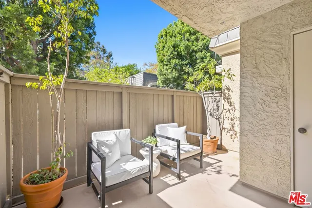 a backyard of a house with table and chairs plants