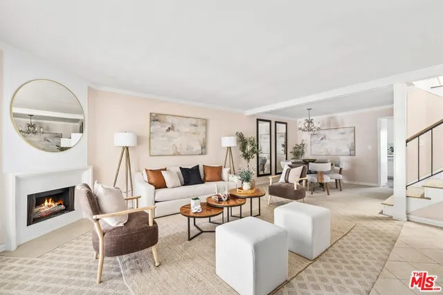 a living room with furniture a fireplace and a large window