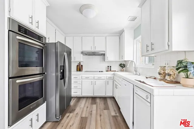 a kitchen with a sink stainless steel appliances and cabinets