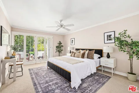 a spacious bedroom with a large bed and a chandelier