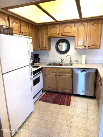 a kitchen with stainless steel appliances granite countertop a sink a stove a refrigerator and a microwave