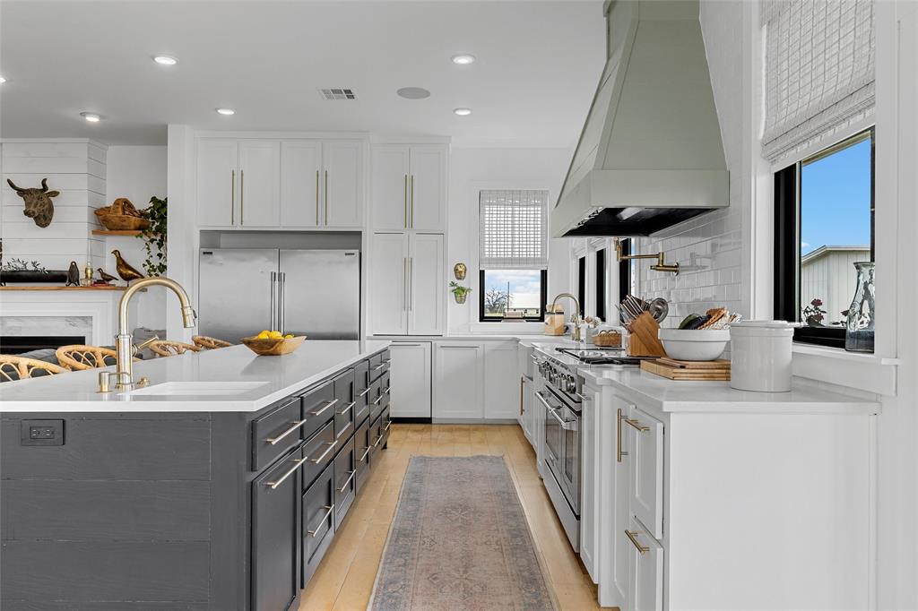1197 Prairie Chapel Road Crawford, TX 76638 - Photo 13 of 40 Kitchen with custom range hood, a sink, high end appliances, white cabinetry, and light countertops