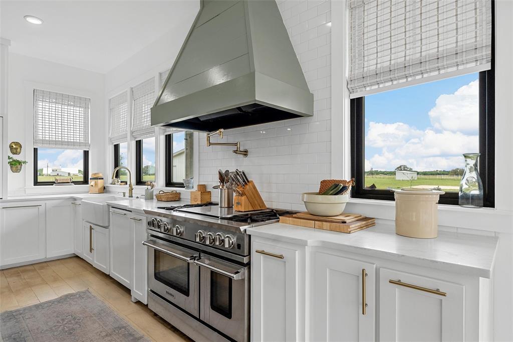 1197 Prairie Chapel Road Crawford, TX 76638 - Photo 14 of 40 Kitchen featuring wall chimney exhaust hood, range with two ovens, a sink, plenty of natural light, and recessed lighting