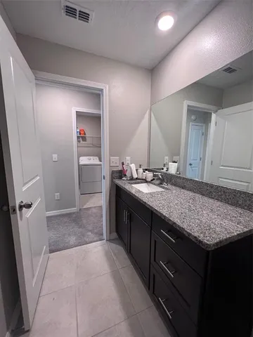 a bathroom with a granite countertop sink and a mirror