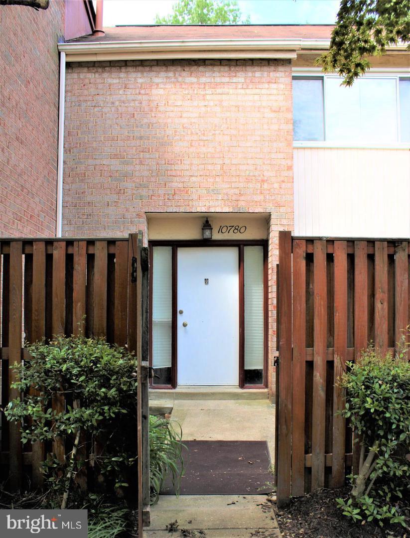 a view of a house with a wooden fence
