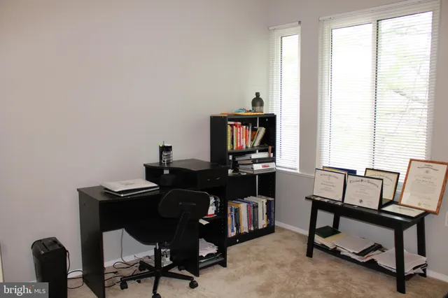 a view of a workspace with furniture and a window