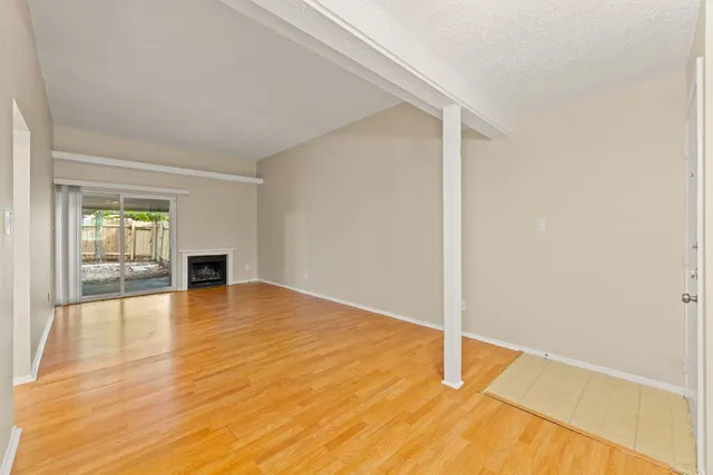 a view of empty room with wooden floor and fireplace