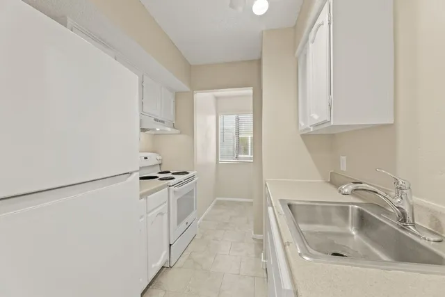 a kitchen with white cabinets and a sink