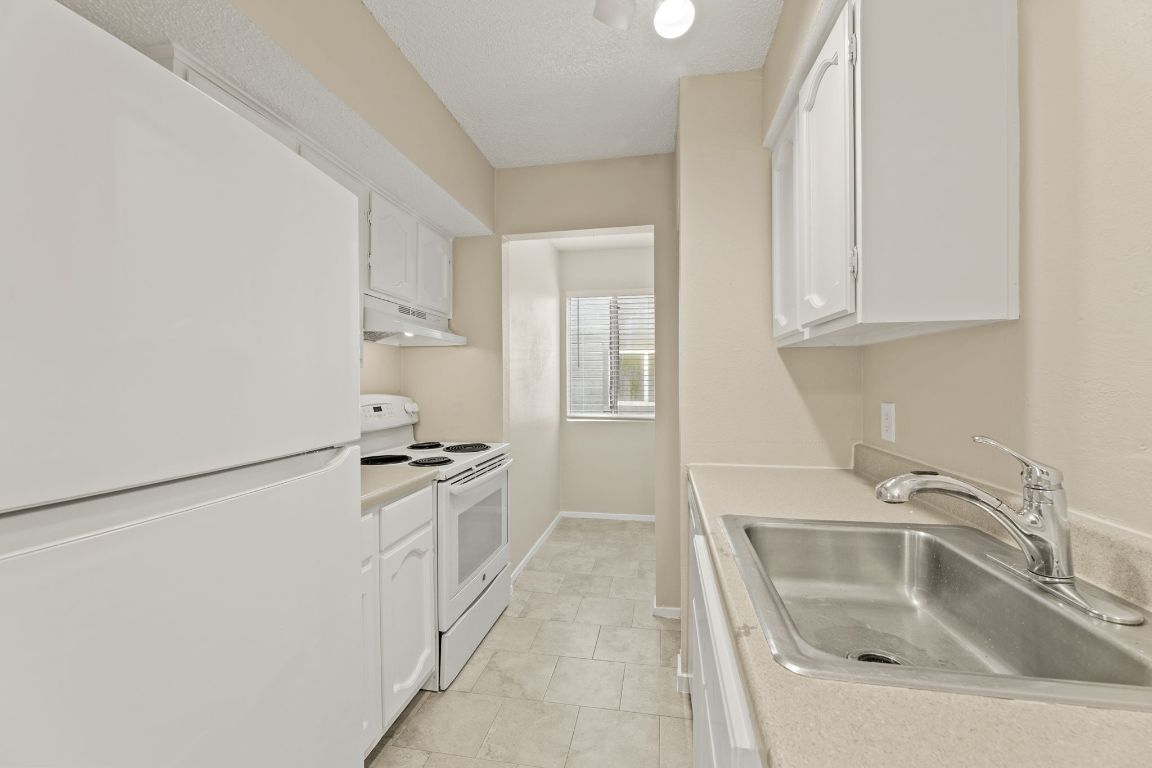 6901 Woodhue Drive, Unit A Austin, TX 78745 - Photo 17 of 34 a kitchen with white cabinets and a sink