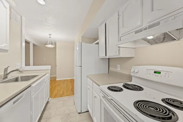 a kitchen with a sink stove and cabinets