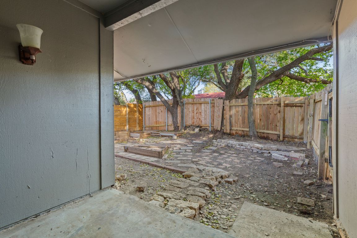 6901 Woodhue Drive, Unit A Austin, TX 78745 - Photo 29 of 34 a view of a backyard with large trees and wooden fence
