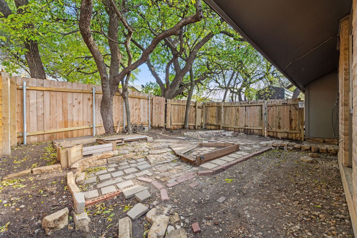 6901 Woodhue Drive, Unit A Austin, TX 78745 - Photo 34 of 34 a view of a backyard with large trees and wooden fence