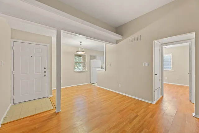 a view of an empty room with wooden floor