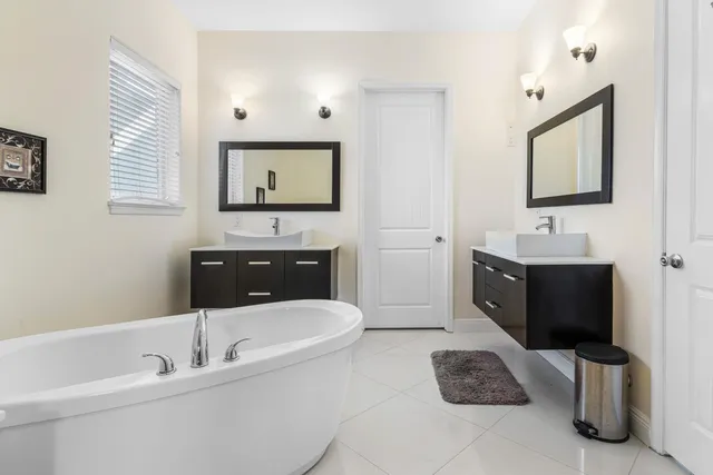 a bathroom with a bathtub a mirror and sink