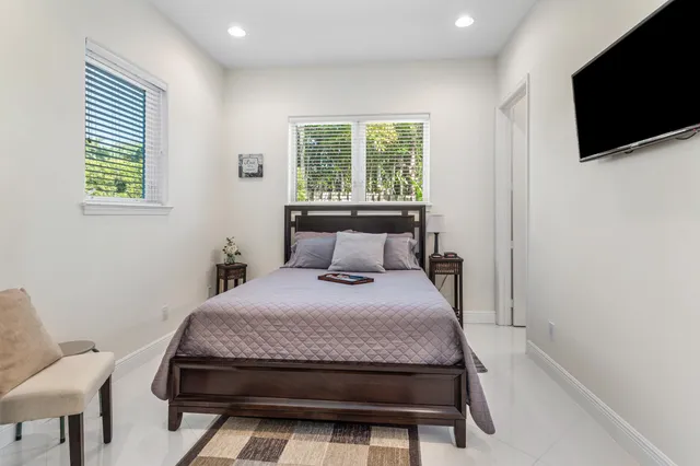 a bed sitting in a bedroom next to a window
