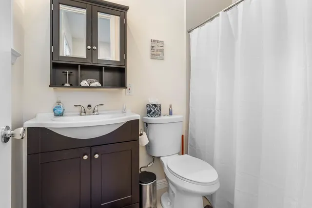 a bathroom with a sink vanity mirror and toilet