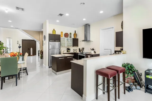 a kitchen with stainless steel appliances kitchen island granite countertop a table and chairs in it