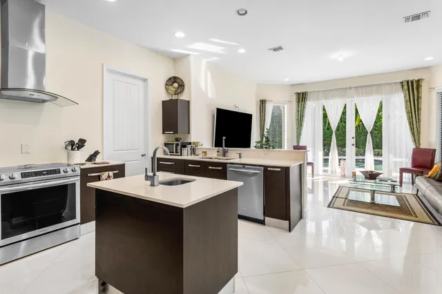 a kitchen with stainless steel appliances kitchen island granite countertop a stove and a sink
