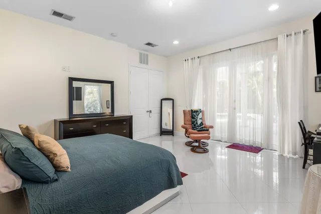 a bedroom with furniture and a large window