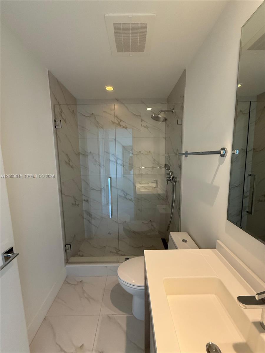 2000 Metropica Way, Unit 901 Sunrise, FL 33323 - Photo 17 of 25 a bathroom with a sink a toilet and shower