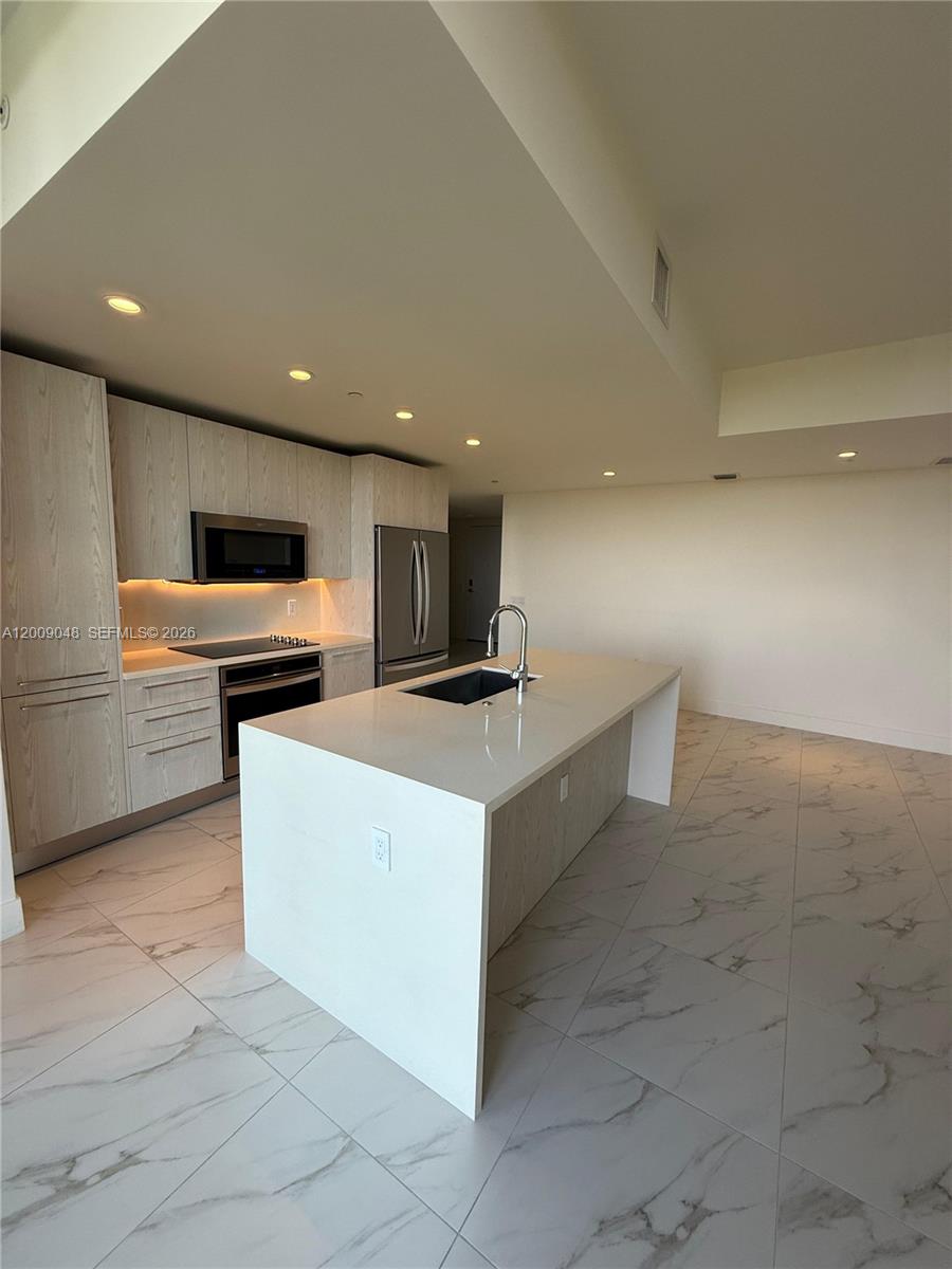 2000 Metropica Way, Unit 901 Sunrise, FL 33323 - Photo 3 of 25 a kitchen with a sink stainless steel appliances and cabinets