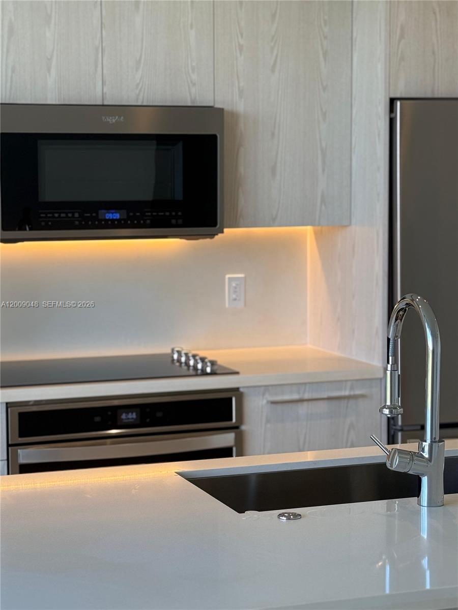 2000 Metropica Way, Unit 901 Sunrise, FL 33323 - Photo 4 of 25 a bathroom with a sink and a microwave