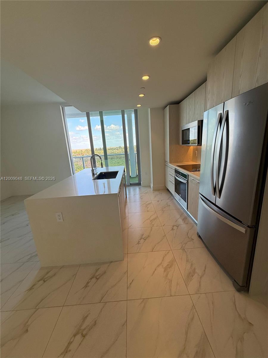 2000 Metropica Way, Unit 901 Sunrise, FL 33323 - Photo 5 of 25 a view of kitchen with furniture and refrigerator