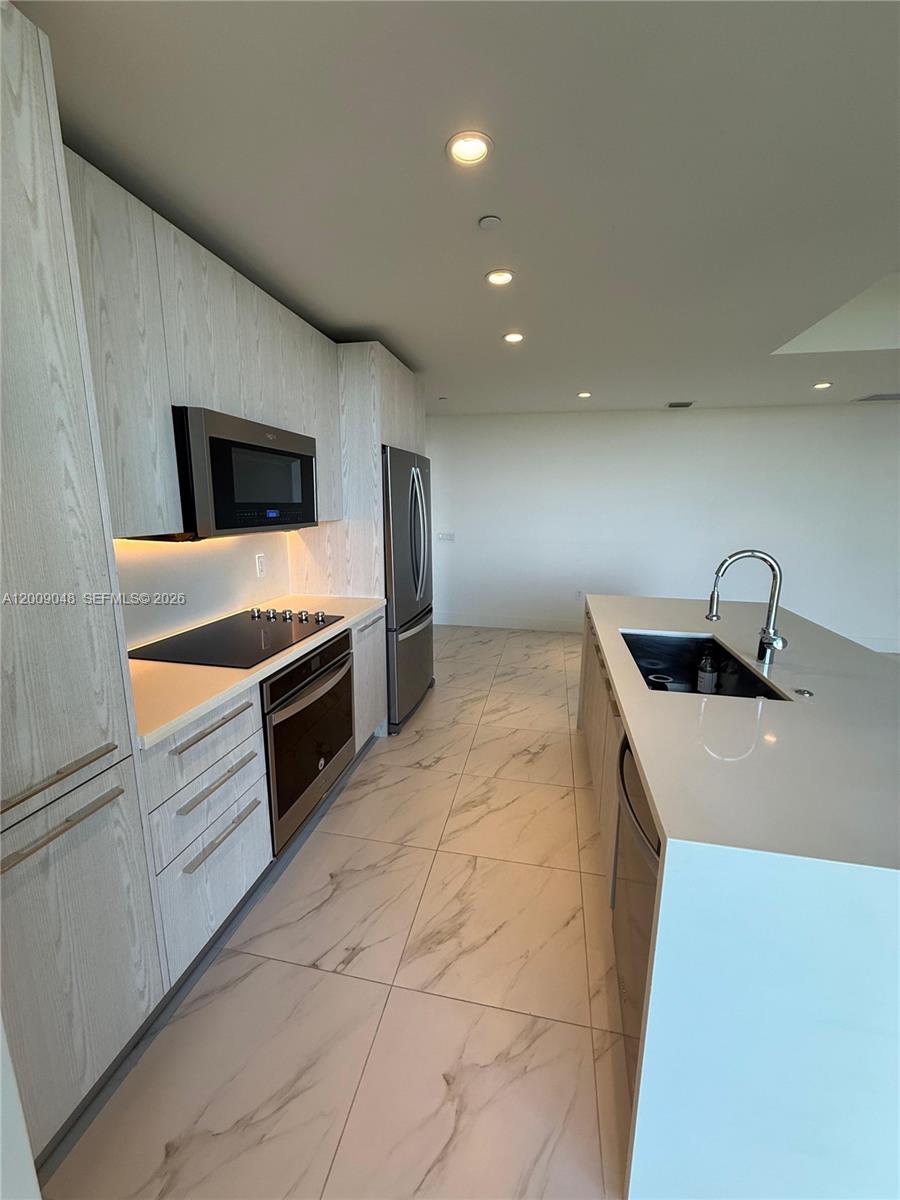 2000 Metropica Way, Unit 901 Sunrise, FL 33323 - Photo 6 of 25 a kitchen with stainless steel appliances a stove a sink and a refrigerator