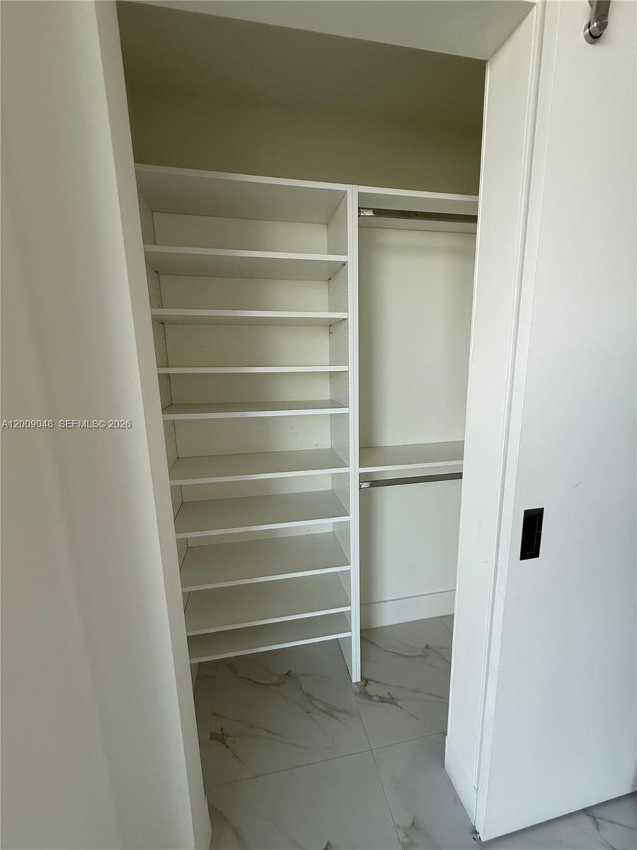 2000 Metropica Way, Unit 901 Sunrise, FL 33323 - Photo 8 of 25 a view of walk in closet with empty racks