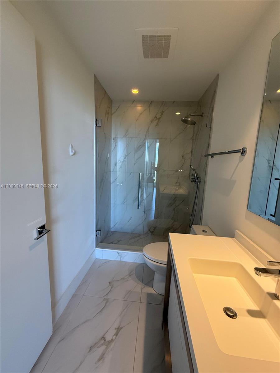2000 Metropica Way, Unit 901 Sunrise, FL 33323 - Photo 9 of 25 a bathroom with a sink a toilet and shower