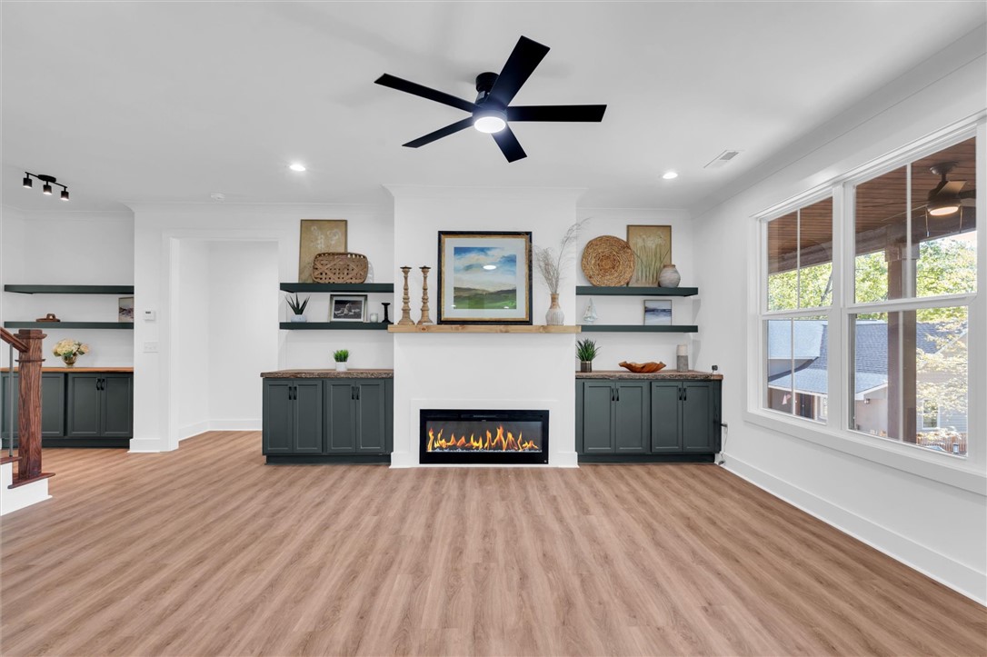 407 Blue Ridge Court Westminster, SC 29693 - Photo 19 of 48 This bright living space features wood flooring, built-in cabinetry, a fireplace, and large windows.