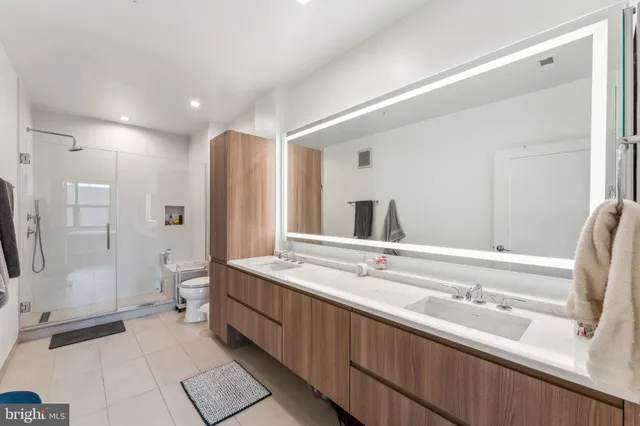 a spacious bathroom with a shower sink and mirror