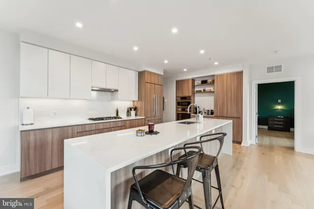 a kitchen with a dining table chairs and white cabinets